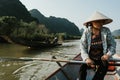 Southeast Asian woman paddling a boat to Thien Tru Temple and the Perfume Pagoda in Hanoi, Vietnam Royalty Free Stock Photo