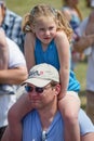 Caucasian father carrying his daughter on his shoulders outside in a park. Caucasian family with blonde child