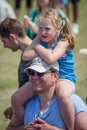 Caucasian father carrying his daughter on his shoulders outside in a park.  Smiling caucasian family with blonde child Royalty Free Stock Photo