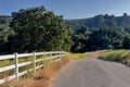 Southern California rural landscape with country road lined with fence. Royalty Free Stock Photo