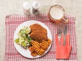 Southern fried chicken fillet meal with green fresh salad and fancy cut potato chips served on white plate and glass of lager beer Royalty Free Stock Photo