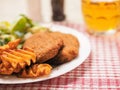 Southern fried chicken fillet meal with green fresh salad and fancy cut potato chips served on white plate and glass of lager beer Royalty Free Stock Photo