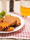 Southern fried chicken fillet meal with green fresh salad and fancy cut potato chips served on white plate and glass of lager beer Royalty Free Stock Photo