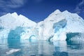 Antarctic iceberg in turquoise and white with caves and texture, dark blue sea ice flows and reflections, Paradise Bay, Antarctica