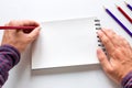The southpaw writes in pencil in a notebook Royalty Free Stock Photo