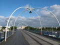 The historic pier in southport merseyside with people walking towards the town and the suspension bridge and buildings visible beh