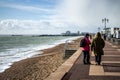 A pair of middle aged women walking along the beach in winter at southsea