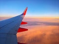 Southwest Airlines flight over clouds at sunset. Wing view