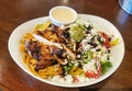 Southwestern Grilled chicken salad with lettuce, guacamole, crispy tortilla strips, serrano peppers, corn, black beans and