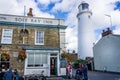 Southwold`s iconic lighthouse seen behind The Sole Bay Inn pub in Southwold, Suffolk, UK