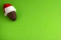 A souvenir ball for rugby or american football in a red santa claus hat on a green background. Preparation for design of posters,