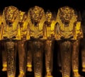 Souvenir figurines of stylized Egyptian images of buried pharaohs in yellow on dark background