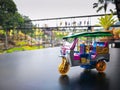 Souvenir mini tuk tuk on Black surface table or road and blur park for background. Thai traditional taxi in Bangkok Thailand Royalty Free Stock Photo