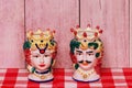 Souvenir from Sicily. Traditional sicilian ceramic pots or vases with heads of a couple of lovers of Moorish heads on red checked
