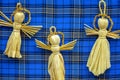 Souvenirs made of straw, toy angels on blue cloth in cage, handmade products. Beautiful gift. Close-up. Royalty Free Stock Photo