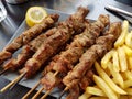 Souvlaki or souvlakia greek ethnic food from roasted meat plate with potatoes and lemon Royalty Free Stock Photo