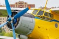 Soviet aircraft biplane Antonov AN-2 with blue four blade propeller and yellow fuselage closeup