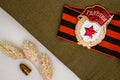 Soviet Bage ÃÂ«GuardÃÂ» and St. George ribbon, dried flowers and bullet on craft background