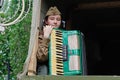 Soviet female soldier in uniform of World War II with an accordion sitting in a military truck on Victory Day in Volgograd