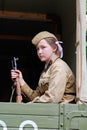 Soviet female soldier in uniform of World War II with a gun sitting in a military truck on Victory Day in Volgograd