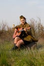 Soviet female soldier in uniform of World War II plays the guitar Royalty Free Stock Photo