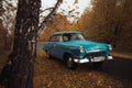 Soviet oldtimer Volga in the autumn forest