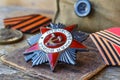 Soviet Order of the Patriotic War inscription Patriotic War and fighting medals on an old wooden table. May 9 victory day in the Royalty Free Stock Photo