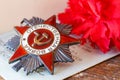 Soviet order of Patriotic war inscription Patriotic war with red carnations on an old wooden table. May 9 Victory day in the gre Royalty Free Stock Photo