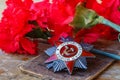 Soviet order of Patriotic War inscription Patriotic war with red carnations on an old wooden table. May 9 day of victory in the