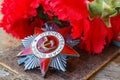Soviet order of Patriotic War inscription Patriotic war with red carnations on an old wooden table. May 9 day of victory in the Royalty Free Stock Photo