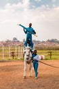 Young African children performing acrobatics on horse back