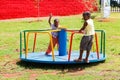 African kids playing merry go round and other park equipment at local public playground