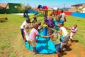 African kids playing merry go round and other park equipment at local public playground