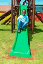 African kids playing on slides and other park equipment at local public playground Royalty Free Stock Photo