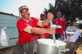 African Woman cooking Mielie Pap maize porridge on side street in urban Soweto