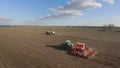 Sowing campaign in early spring. Three tractors pull seeders, aerial 4K video