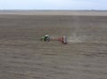 Sowing of corn. Tractor with a seeder on the field. Using a seeder for planting corn.