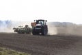 Sowing time.tractor trailer rides on the field and sows grain