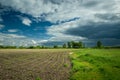 Sown rural field and coming cloudy sky
