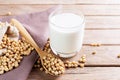 Soy milk in a glass with soybeans on a wooden table Organic breakfast, high protein, healthy, agricultural products, vegetarian