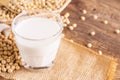 Soy milk in a glass with soybeans on a wooden table Organic breakfast, high protein, healthy, agricultural products, vegetarian