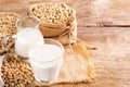 Soy milk in a glass with soybeans on a wooden table Organic breakfast, high protein, healthy, agricultural products, vegetarian