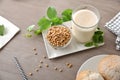 Soy milk on a plate with bowl full of soybeans