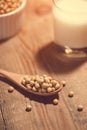 Soy milk or soya milk and soy beans in spoon on wooden table. Royalty Free Stock Photo