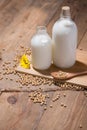 Soy milk or soya milk and soy beans in spoon on wooden table. Royalty Free Stock Photo