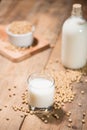 Soy milk or soya milk and soy beans on wooden table. Royalty Free Stock Photo