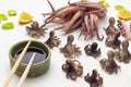 Soy sauce in bowl and bamboo sticks. Boiled octopus babies on table Royalty Free Stock Photo