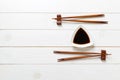 Soy sauce with chopsticks on white wooden table background Royalty Free Stock Photo
