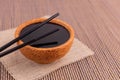 Soy sauce in a wooden bowl with chopsticks. Royalty Free Stock Photo