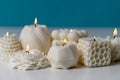 Soy wax handmade candles on white table against blue background. Delicate scented candle made of natural materials
